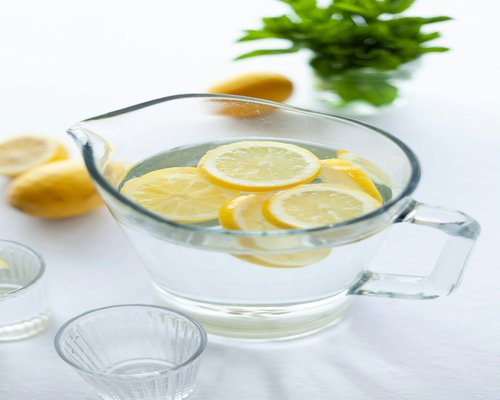 A glass pitcher with fresh water and lemon slices