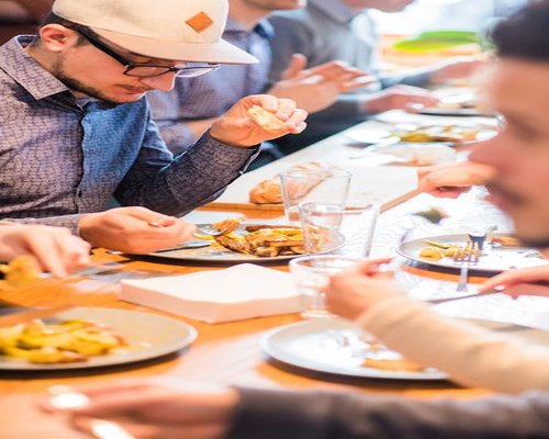 People sitting at a table eating slowly and conversing